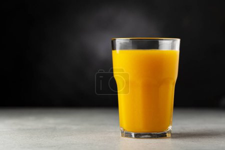 Mango juice in glass cup on the table. Mango smoothie.