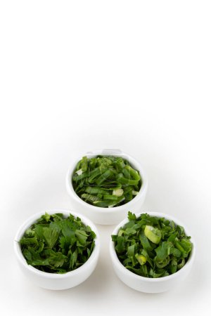 Photo for Sliced cilantro, chives and parsley in ramekin - Royalty Free Image
