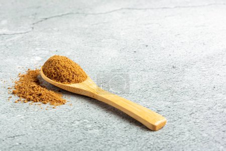 Foto de Azúcar moreno en cuchara de madera sobre la mesa. - Imagen libre de derechos