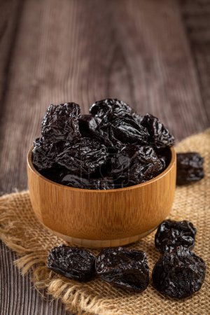 Bowl with prunes on the table.