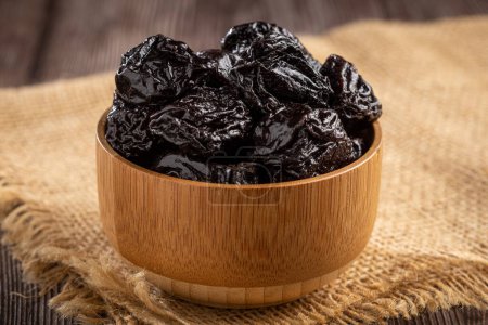Bowl with prunes on the table.