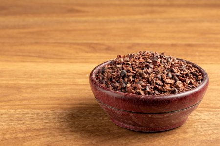 Bowl with cocoa nibs on the table.