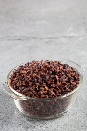 Photo for Bowl with cocoa nibs on the table. - Royalty Free Image
