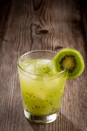 Photo for Brazilian Kiwi Caipirinha. Cachaa drink with kiwi, on wooden background - Royalty Free Image