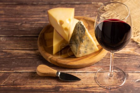 Käseplatte mit einem Glas Rotwein.