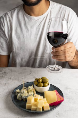Man tasting wine and cheese.