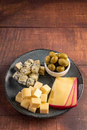Teller mit verschiedenen Käsesorten auf dem Tisch. Käsestücke.