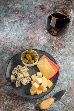 Foto de Placa de diferentes quesos con una copa de vino. Tablero de queso. - Imagen libre de derechos