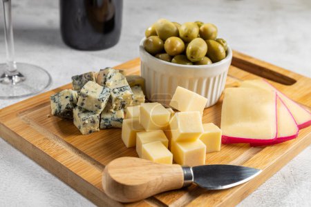 Téléchargez les photos : Assiette de différents fromages avec un verre de vin. Plateau de fromage. - en image libre de droit
