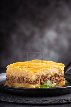 Photo for Piece of shepherd's pie on dark plate. - Royalty Free Image