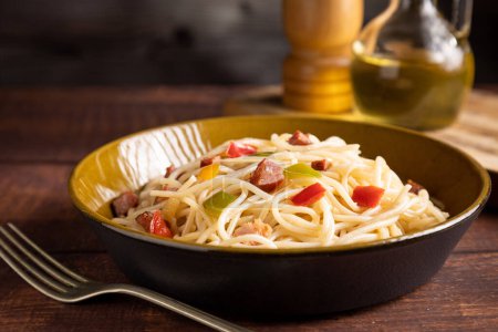 Téléchargez les photos : Assiette avec spaghettis, bacon et légumes hachés. - en image libre de droit