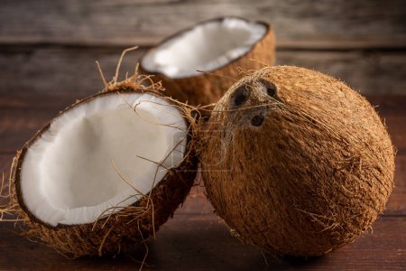 Photo for Whole coconut and pieces of coconut on the table. - Royalty Free Image