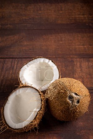 Photo for Whole coconut and pieces of coconut on the table. - Royalty Free Image