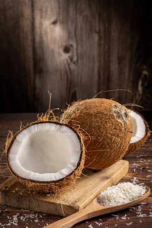 Téléchargez les photos : Noix de coco entière, morceaux de noix de coco et noix de coco râpée sur la table. - en image libre de droit