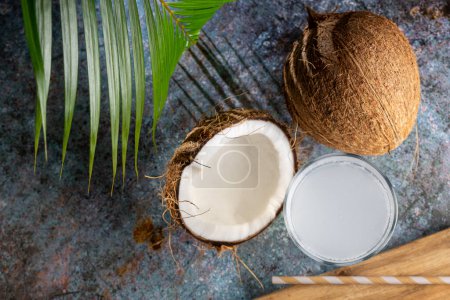 Foto de Vidrio con agua de coco fresca y cocos sobre la mesa. - Imagen libre de derechos