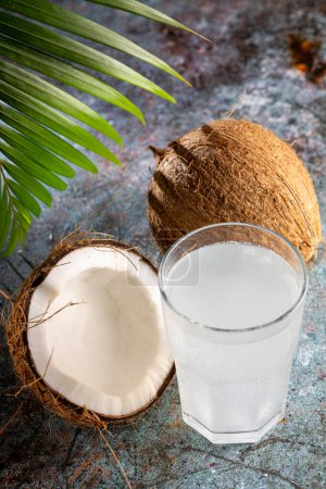 Photo for Glass with fresh coconut water and coconuts on the table. - Royalty Free Image