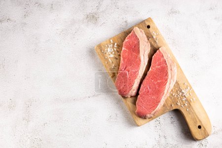 Téléchargez les photos : Steak picanha cru sur la planche à découper. - en image libre de droit