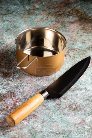 Foto de Cuchillo de cocina y chef en la mesa. Sartén metálica. - Imagen libre de derechos