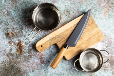 Foto de Cuchillo de cocina y chef en la mesa. Sartén metálica. - Imagen libre de derechos