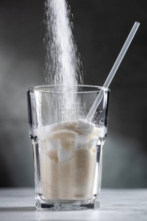 Foto de Llenar el vaso con azúcar. Concepto de alimentos poco saludables. - Imagen libre de derechos