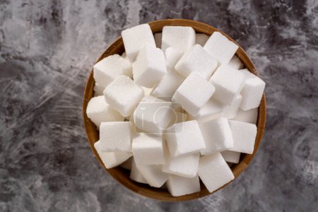 Téléchargez les photos : Cubes de sucre blanc dans un bol en bois
. - en image libre de droit