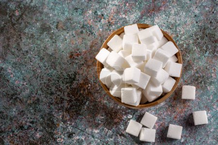 Foto de Cubos de azúcar blanco en cuenco de madera
. - Imagen libre de derechos