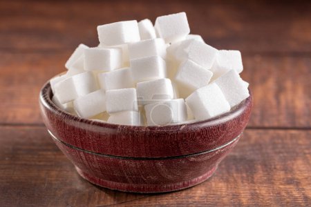 Photo for White sugar cubes in wooden bowl. - Royalty Free Image