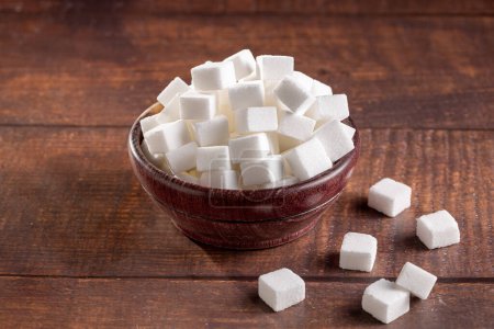 Photo for White sugar cubes in wooden bowl. - Royalty Free Image