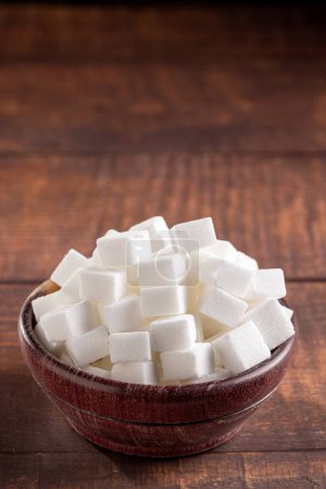 Téléchargez les photos : Cubes de sucre blanc dans un bol en bois
. - en image libre de droit
