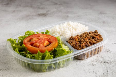 Téléchargez les photos : Boîte à lunch avec salade de laitue aux tomates, riz et boeuf haché. - en image libre de droit