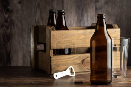 Botellas de cerveza de ámbar vacías sobre fondo rústico de madera.