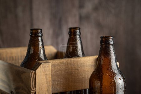 Botellas de cerveza de ámbar vacías sobre fondo rústico de madera.