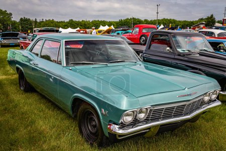Photo for Iola, WI - July 07, 2022: High perspective front corner view of a 1965 Chevrolet Impala 2 Door Hardtop at a local car show. - Royalty Free Image