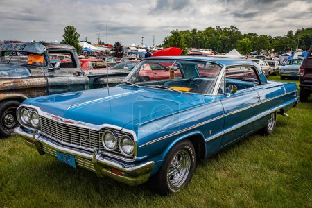 Photo for Iola, WI - July 07, 2022: High perspective front corner view of a 1964 Chevrolet Impala Sport Coupe at a local car show. - Royalty Free Image