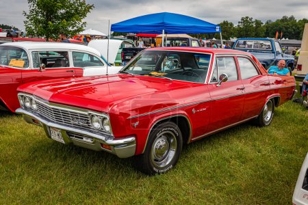 Photo for Iola, WI - July 07, 2022: High perspective front corner view of a 1966 Chevrolet Impala 4 Door Sedan at a local car show. - Royalty Free Image