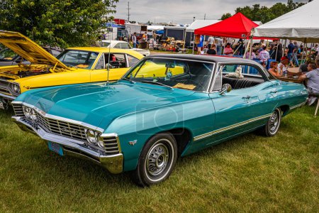 Photo for Iola, WI - July 07, 2022: High perspective front corner view of a 1967 Chevrolet Impala 4 Door Hardtop at a local car show. - Royalty Free Image