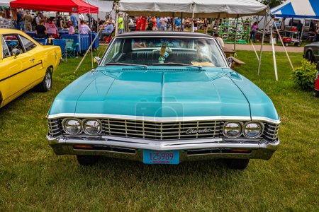 Photo for Iola, WI - July 07, 2022: High perspective front view of a 1967 Chevrolet Impala 4 Door Hardtop at a local car show. - Royalty Free Image