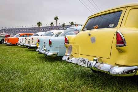 Photo for Daytona Beach, FL - November 11, 2022: Low perspective rear corner view of a group of parked 1955 Chevrolet Nomads, BelAirs, and 210 models at a local car show. - Royalty Free Image
