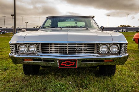 Photo for Daytona Beach, FL - November 26, 2022: Low perspective front view of a 1967 Chevrolet Impala Convertible at a local car show. - Royalty Free Image