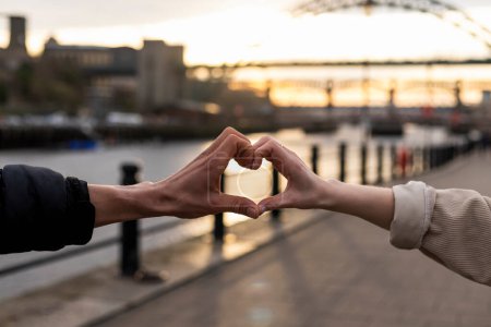 Photo for An unrecognisable couple spending the day in Newcastle Upon Tyne together. They are putting their hands together and creating a heart shape. - Royalty Free Image
