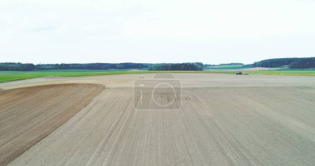 Téléchargez les photos : Prise de vue du tracteur travaillant sur le terrain. L'agriculteur laboure le champ avant de planter du blé. - en image libre de droit