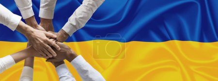 Foto de Las manos o el pueblo unido en la bandera ucraniana entrega juntos sobre la bandera nacional de Ucrania, en demostración de unión contra la escalada de la guerra. Resistencia del pueblo ucraniano a la guerra contra Rusia. - Imagen libre de derechos