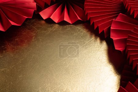 Téléchargez les photos : Chinese Lunar New Year golden background with red paper fans. Asian traditional cultural decoration. Copy space for a party. - en image libre de droit