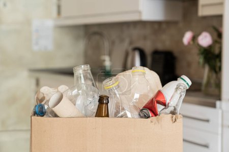 Téléchargez les photos : Recycling concept - box of recycling materials in kitchen background. High quality photo - en image libre de droit