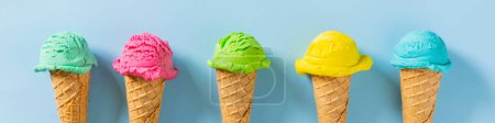 Photo for Colorful ice cream scoops in cones, bright blue background. Top view - Royalty Free Image