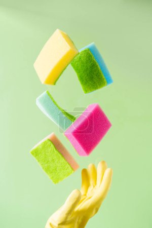 Photo for Cleaning concept - levitation of dishwashing sponges on green background, copy space - Royalty Free Image