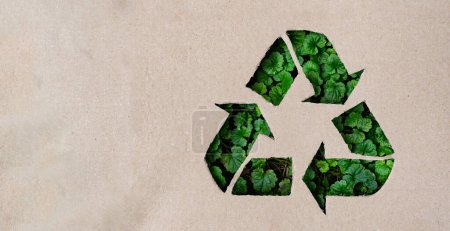 Foto de Concepto de reciclaje - símbolo de reciclaje hecho en cartón conhierba verde en el fondo. Vista superior de fotos de alta calidad - Imagen libre de derechos