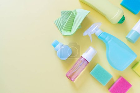 Photo for Cleaning concept - cleaning supplies on pastel yellow background, top view - Royalty Free Image