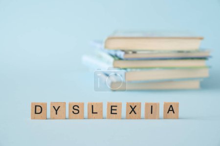 Téléchargez les photos : Concept de dyslexie - nom du trouble sur les livres, fond bleu. Photo de haute qualité - en image libre de droit