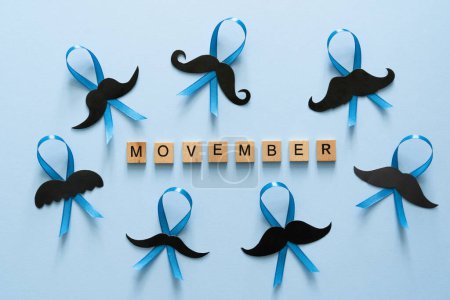 Téléchargez les photos : Concept Movember - événement de sensibilisation aux questions de santé masculine, moustache et ruban bleu, vue de dessus - en image libre de droit